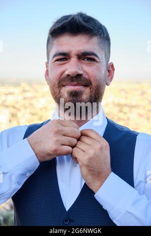 Man buttons his white shirt up Stock Photo