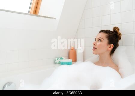 Young white woman relaxing in a bubble bath Stock Photo