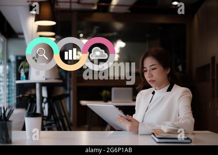 Young woman Accountant do audit tax of company by digital tablet in application on cloud with virtual icon on screen Stock Photo