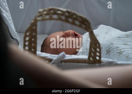 A baby yawning in a cot Stock Photo