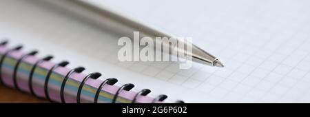 Metal ballpoint pen lying on notepad closeup Stock Photo