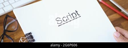 Female hands holding script over table closeup Stock Photo