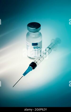 A syringe next to a vaccination vial Stock Photo
