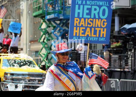 July 7, 2021, New York City, New York, USA: It was under a blazing sun that NYC honored essential workers at parade up Canyon of Heroes. The people dispatched in 260 groups who helped get New York City through the COVID-19 pandemic have walked with a parade up Broadway to the cheers of thousands of spectators. All front lines including nurses, doctors, first responders, paramedic, teachers, firefighters, metro employees, NYPD, bus drivers have ride in music on floats through a canyon of tall buildings and falling confetti. Between joy and demands in the presence of the outgoing mayor, Bill de Stock Photo