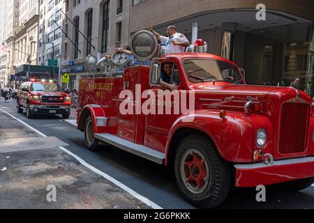 NEW YORK, NY - JULY 07: New York Fire Department members ride an old FDNY Searchlight Truck during the 'Hometown Heroes' Ticker Tape Parade on July 07, 2021 in New York City. Healthcare Workers, first responders and essential workers are honored in Manhattan's Canyon of Heroes for their service during the Covid-19 pandemic. Stock Photo