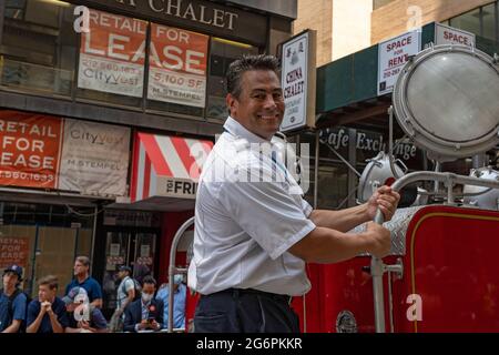 NEW YORK, NY - JULY 07: New York Fire Department members ride an old FDNY Searchlight Truck during the 'Hometown Heroes' Ticker Tape Parade on July 07, 2021 in New York City. Healthcare Workers, first responders and essential workers are honored in Manhattan's Canyon of Heroes for their service during the Covid-19 pandemic. Stock Photo