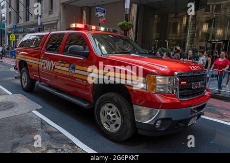 NEW YORK, NY - JULY 07: New York Fire Department members ride a FDNY truck during the 'Hometown Heroes' Ticker Tape Parade on July 07, 2021 in New York City. Healthcare Workers, first responders and essential workers are honored in Manhattan's Canyon of Heroes for their service during the Covid-19 pandemic. Stock Photo