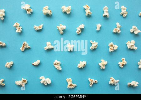 Popcorn scattered on blue background. Popcorn pattern. top view. Stock Photo