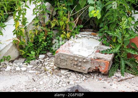 Сonstruction garbage, debris and waste rubble in a remote green forest area. Nature and soil pollution concept. Stock Photo