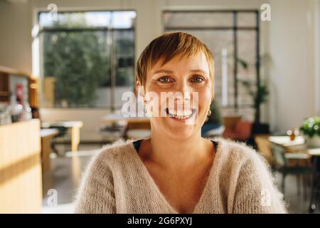 businesswoman in co-working space and smiling. Close-up of a cheerful female executive in office. Stock Photo
