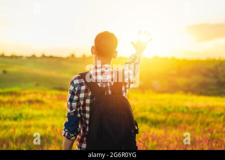 Back view, Human hand, tourist covering sunlight, Sun shining through hand, Human hand and sun, travel concept, tourism Stock Photo