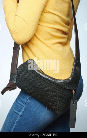 Small black leather bag on woman waist isolated close up view Stock Photo
