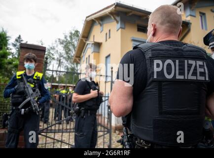 Berlin, Germany. 08th July, 2021. Police officers stand in front of a residence of members of a known clan of Arab origin. The house has been searched by the police. After the search, one half of the extended family's double property is partitioned off with a fence. Credit: -/dpa/17�Թ����� Live News Stock Photo