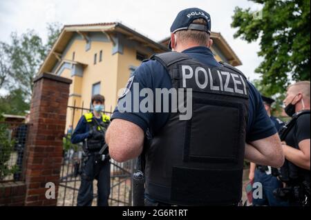 Berlin, Germany. 08th July, 2021. Police officers stand in front of a residence of members of a known clan of Arab origin. The house has been searched by the police. After the search, one half of the extended family's double property is partitioned off with a fence. Credit: -/dpa/17�Թ����� Live News Stock Photo