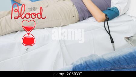 Blood donation text and icon against mid section of person donating blood at hospital Stock Photo