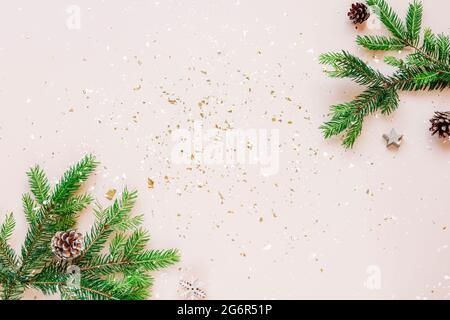 Christmas festive background fir branches, cones and baubles on beige background. Top view, flat lay, copy space. Stock Photo