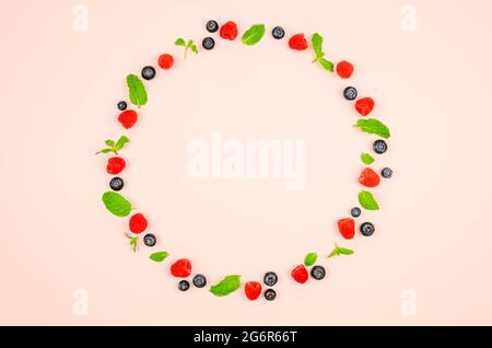 Fresh blueberries, raspberries and mint leaf on top view with pastel pink color background for healthy food concept. Stock Photo