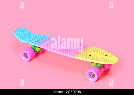 rainbow plastic Penny board skateboard isolated on pink background Stock Photo