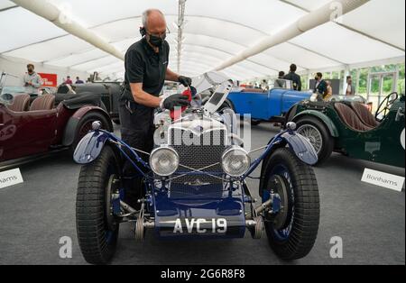 Chris Bailey, car presentation leader at Bonhams, cleans a 1936 Riley 1.5litre TT Sprite on display in the Bonhams Saleroom at the Goodwood Estate, Chichester, West Sussex, which is estimated to fetch £200-300,000 in the Bonhams Festival of Speed Sale on Friday. Picture date: Thursday July 8, 2021. Stock Photo