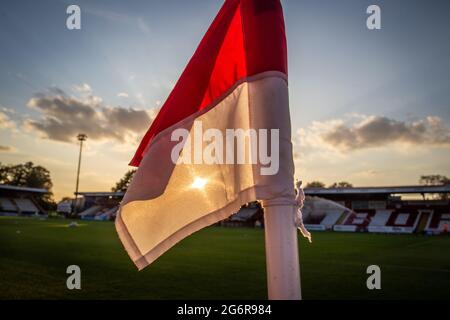 Close up of corner flag fluttering backlit by sun at football ground in UK