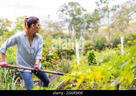 woman working in her vegetable garden with a shovel Stock Photo