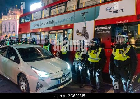 London, UK. 07th July, 2021. Riot police protect a bus after England football fans who boarded it smashed a window during Londonís west end celebration of England beating Denmark in the UEFA Euro 2020 semi-final. Credit: SOPA Images Limited/Alamy Live News Stock Photo