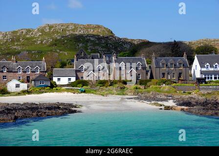 Coastal houses looking towards the short stretch of water between Iona and Mull, Iona, Scotland Stock Photo