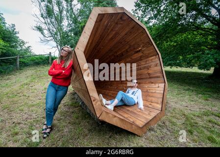 Ardingly, UK.  8 June 2021. Staff members experience 'RUUP: Forest Megaphones' by Birgit Olgus, one of three giant wooden megaphones.  Preview of Summer of Sound where six striking large-scale sound installations takeover Wakehurst, Kew’s wild botanic garden in Sussex.  Artists have created installations offering moments to pause and feel connected to nature through a symphony of sounds created or inspired by the natural world.  Summer of Sound runs 9 July to 12 September 2021. Credit: Stephen Chung / Alamy Live News Stock Photo