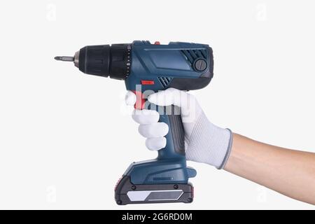 Master in glove holds a drill with drill on white background Stock Photo