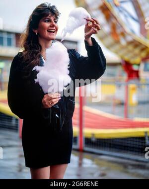 young woman eating candy floss at a fairground 1990s england uk Stock Photo