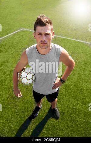 Football player with a ball standing in the field Stock Photo