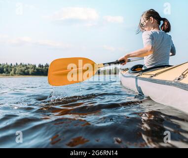 Young independent woman is sailing alone on a boat on the river. Stock Photo