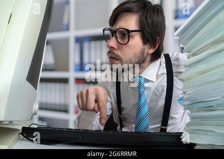 Young man is working with desktop computer in office. Stock Photo