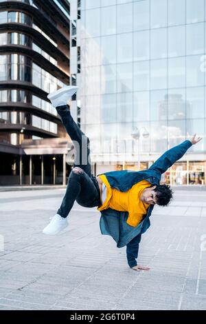 Talented young man dancing in the street and practicing break dance. Stock Photo