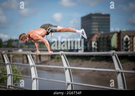 Man Doing Calisthenics Outdoors. Guy working out in the Street. Sport Fitness Concept. Stock Photo