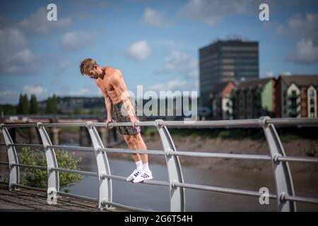 Man Doing Calisthenics Outdoors. Guy working out in the Street. Sport Fitness Concept. Stock Photo
