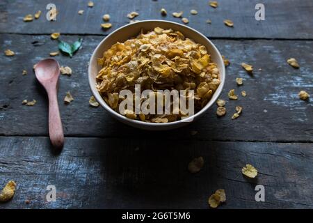 Raw cornflakes in a bowl food background. Close up. Stock Photo