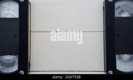 white wooden background with old black vhs tapes on both sides Stock Photo