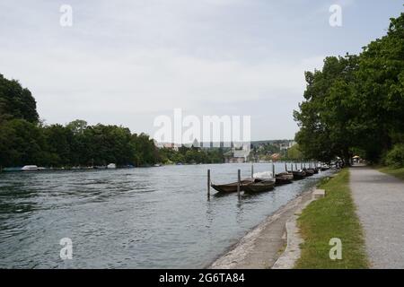 Promenade along Rhine river in Schaffhausen, Switzerland. There are wooden boats moored along the river bank. They are called weidling boot in German. Stock Photo