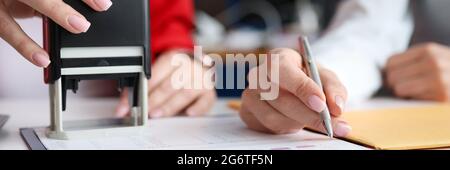 Business women signing document and certifying seal closeup Stock Photo