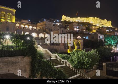 Stairway of Mardin Museum and illuminated Mardin Castle in the evening Stock Photo