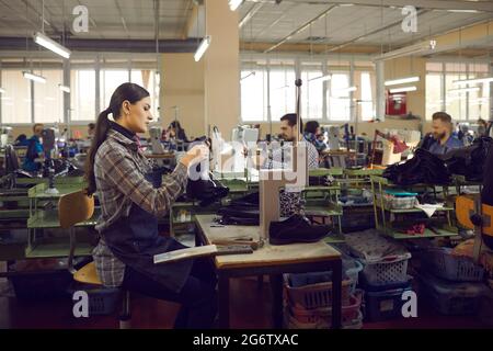 Young professional female shoemaker designer working with leather at workplace Stock Photo