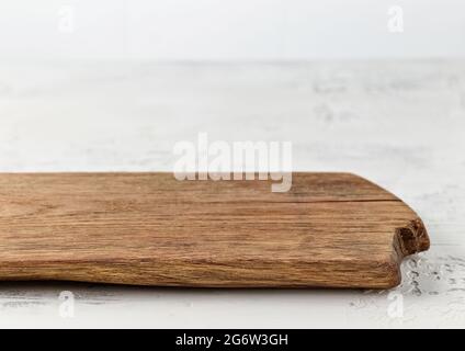 old empty wooden cutting board on white kitchen table Stock Photo