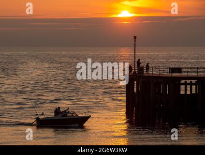 Aberystwyth, Ceredigion, Wales, UK. 08th July 2021  UK Weather: A small pleasure boat heads back to harbour in Aberystwyth, as the sun sets over the west coast at the end of a warm summer’s day. © Ian Jones/Alamy Live News Stock Photo