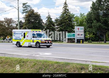 London, Ontario, Canada - June 22 2021: A Middlesex-London EMS paramedic ambulance drives down Wellington Road with its lights flashing. Stock Photo