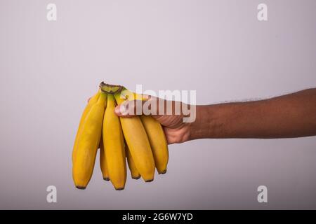A bunch of bananas held by a man. Appetizing bananas isolated on white background. Stock Photo