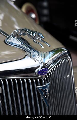 A greyhound hood ornament on the front of a 1934 Ford Phaeton V8 on display at a Fourth of July classic car show in Santa Fe, New Mexico. Stock Photo