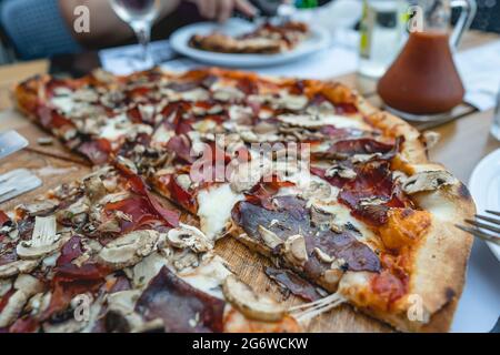 Close up on sliced baked pizza on the table at home or restaurant Stock Photo