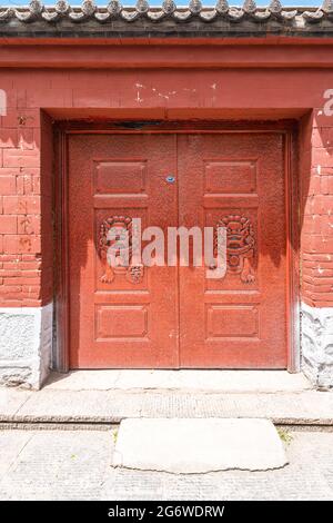 Chinese ancient traditional red wooden door and brick wall Stock Photo