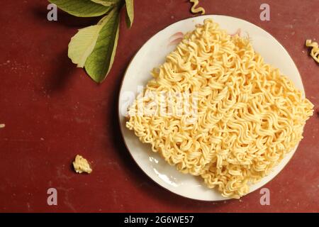 Uncooked noodles food on plate, top view Stock Photo